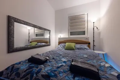 a bedroom with a bed and a large mirror at Oaza Apartmani Jakovo AFRODITA in Jakovo