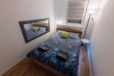 a small bedroom with a bed and a mirror at Oaza Apartmani Jakovo AFRODITA in Jakovo