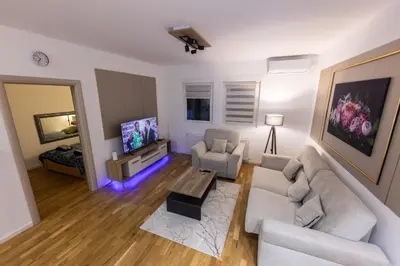 a living room with a couch and a tv at Oaza Apartmani Jakovo AFRODITA in Jakovo
