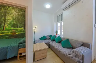 a living room with a couch and a large window at Cozy Little Place - Parking Available in Belgrade