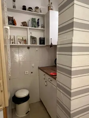 a small kitchen with white cabinets and a stool at Belgrade Central Residence in Belgrade