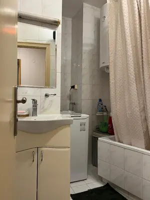 a white bathroom with a sink and a mirror at Belgrade Central Residence in Belgrade