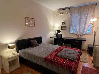 a bedroom with a bed and a desk and a piano at Belgrade Central Residence in Belgrade