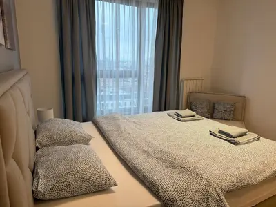 a bedroom with a bed with two pillows and a window at Beograd na vodi Lux apartman BW Magnificent City View in Sajmište