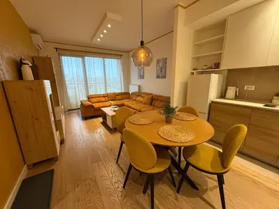a kitchen and living room with a table and chairs at Beograd na vodi Lux apartman BW Magnificent City View in Sajmište