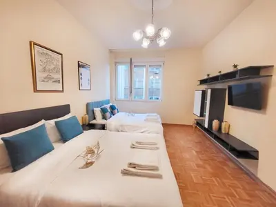 a large bedroom with two beds and a television at Skaradlija Lux Apartment in Belgrade