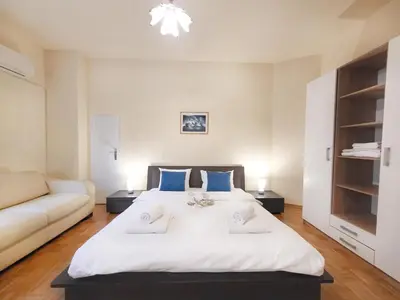 a bedroom with a large white bed and a couch at Skaradlija Lux Apartment in Belgrade