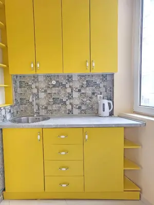 a kitchen with yellow cabinets and a sink at Skaradlija Lux Apartment in Belgrade