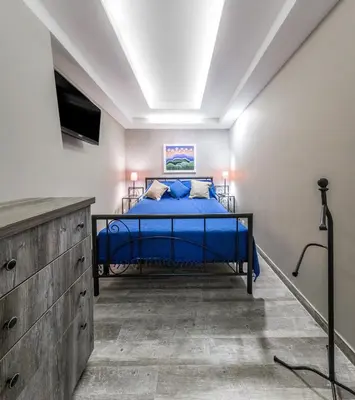 a bedroom with a blue bed and a television at Belgrade Penthouse - among the clouds in Belgrade