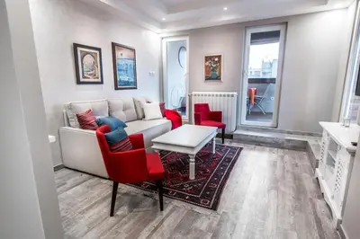 a living room with a couch and red chairs at Belgrade Penthouse - among the clouds in Belgrade