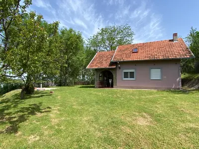 a house with a grassy yard in front of it at Vikendica Lela in Beška
