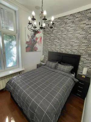 a bedroom with a large bed with a brick wall at World Traveler in Belgrade