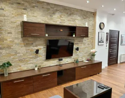 a large living room with a tv on a brick wall at World Traveler in Belgrade