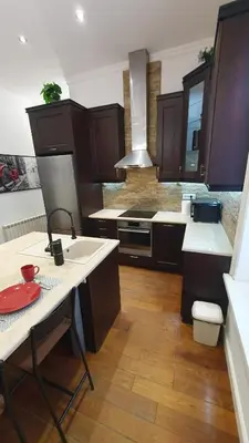 a kitchen with brown cabinets and a table with a red plate at World Traveler in Belgrade
