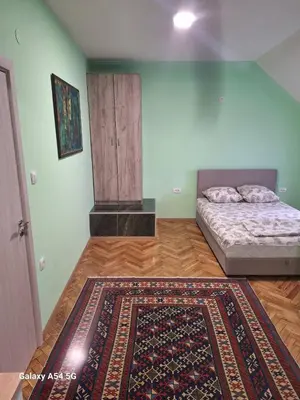 a bedroom with a bed and a rug on a wooden floor at Dream 9 in Belgrade