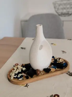 a white vase sitting on a tray of shells at Park Residence Apartman 1, Mirijevo, Beograd in Belgrade