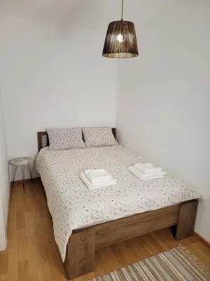 a bed in a bedroom with a pendant light at Park Residence Apartman 1, Mirijevo, Beograd in Belgrade