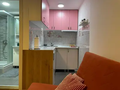 a kitchen with pink cabinets and a sink at Central duplex apartment in Belgrade