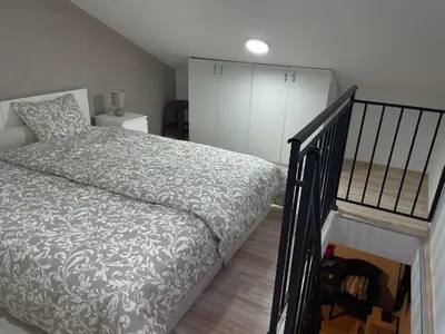 a bedroom with a bed next to a staircase at Central duplex apartment in Belgrade