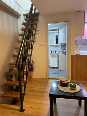 a living room with a staircase and a table at Central duplex apartment in Belgrade