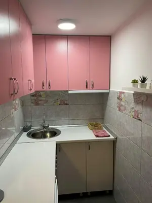 a kitchen with pink cabinets and a sink at Central duplex apartment in Belgrade