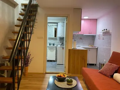 a living room with a couch and a kitchen at Central duplex apartment in Belgrade
