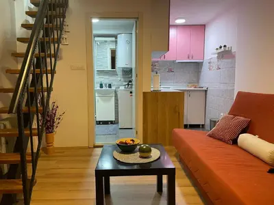 a living room with an orange couch and a table at Central duplex apartment in Belgrade