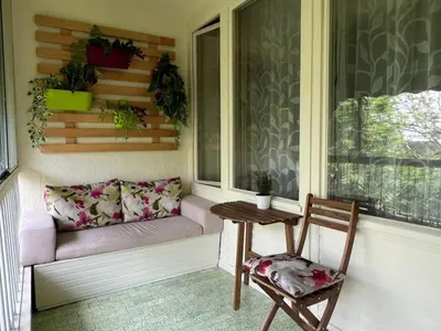 a porch with a couch and a table and a chair at R&R Apartmant Konjarnik in Belgrade