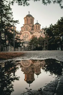 a church with its reflection in a puddle at Adagio 7 in Belgrade