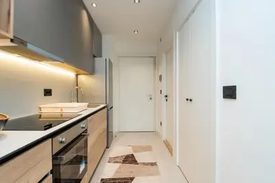 a kitchen with white cabinets and a sink at BW Simfonija 1 in Belgrade