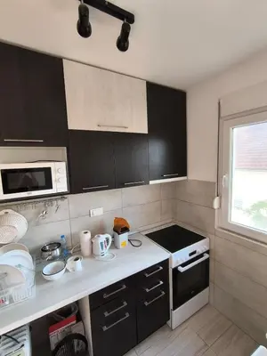 a kitchen with black cabinets and a white counter top at Apartment for a day, Zemun, Altina, two rooms in Belgrade