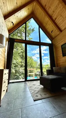a living room with a large window in a house at Cabin 16 in Čolakovica Potok