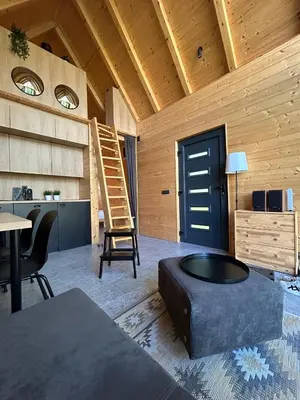 a living room with a table and a blue door at Cabin 16 in Čolakovica Potok