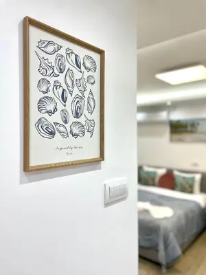 a drawing of shells on a wall next to a bed at Perla Suite Vracar in Belgrade