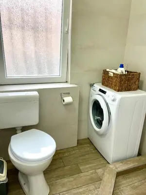 a bathroom with a toilet and a washing machine at Perla Suite Vracar in Belgrade