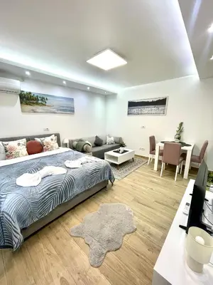 a bedroom with a bed and a living room at Perla Suite Vracar in Belgrade