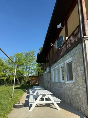 a group of picnic tables outside of a building at Zen Cherry House- Vikendica na dan sa bazenom1,5ha izmedju Avale i Kosmaja in Drobnjaci