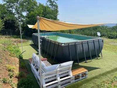 a swimming pool with a canopy and chairs next to a table at Zen Cherry House- Vikendica na dan sa bazenom1,5ha izmedju Avale i Kosmaja in Drobnjaci