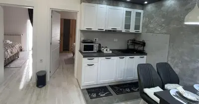 a kitchen with white cabinets and a microwave at Apartman Manda in Belgrade