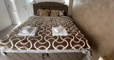 a bed with two towels and pillows on it at Apartman Manda in Belgrade
