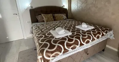 a large bed with two towels on top of it at Apartman Manda in Belgrade