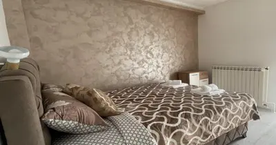 a bedroom with a bed and a wall at Apartman Manda in Belgrade