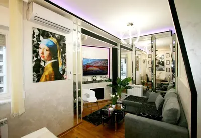 a living room with a couch and a painting on the wall at Apartment Purple in Belgrade