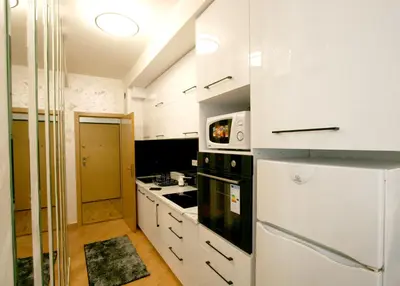 a white kitchen with a stove and a refrigerator at Apartment Purple in Belgrade