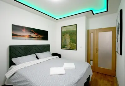 a bedroom with a bed with a green ceiling at Apartment Purple in Belgrade