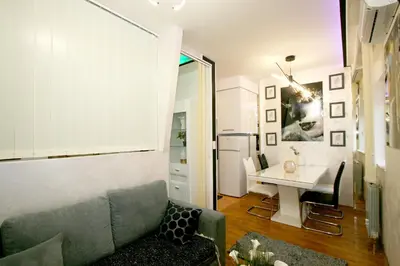a living room with a couch and a table at Apartment Purple in Belgrade