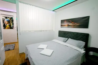 a bedroom with a bed with two white towels on it at Apartment Purple in Belgrade
