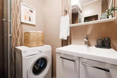 a bathroom with a washing machine and a sink at Bright Harmony with Balcony Old Town Renovated in Belgrade