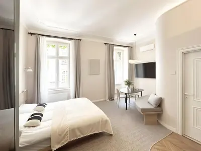 a white bedroom with a bed and a table at Design Suite in Prime Location Superstring Home in Belgrade
