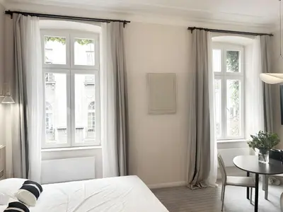 a bedroom with a bed and a table and windows at Design Suite in Prime Location Superstring Home in Belgrade